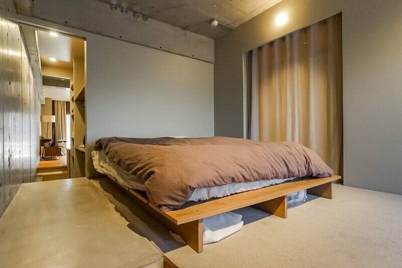 ベッドが置かれた場所はカーペット敷き。右手のカーテンを開けるとガラス越しに廊下が見えます。その奥が洋室Bという配置。