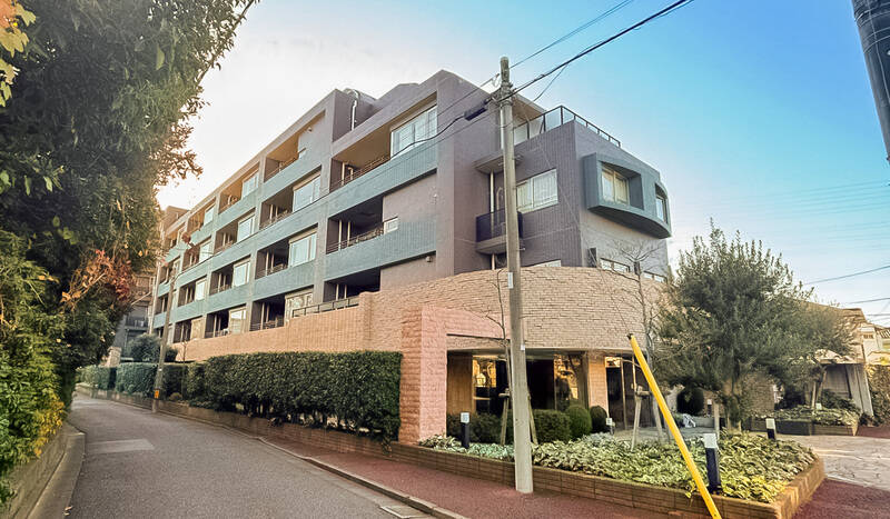 総戸数46戸、6階建てのマンション。外壁は色違いのタイルを貼り分け、エントランス周りには素材感のある石調の部材をあしらった外観です。