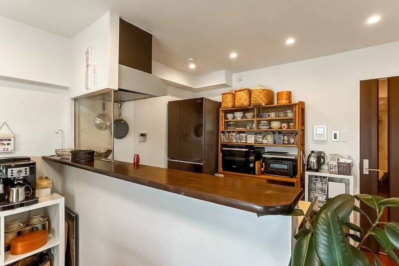 キッチンカウンターは高めに設計されており、手元が隠れるのがうれしい。背面には大型のカップボードを配置できます。