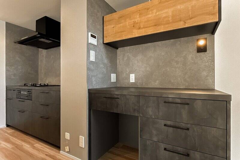 キッチン背面には3口コンロと並んで、お揃いのデザインのカップボードを設置済み。ゴミ箱もカウンター下にスッキリと収まります◎