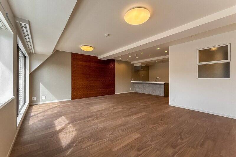 リビングダイニング（LD）の一部には、レッドブラウンのニュアンスを帯びたアクセントパネルを採用。床の温かみのある色調ともよく調和しています。