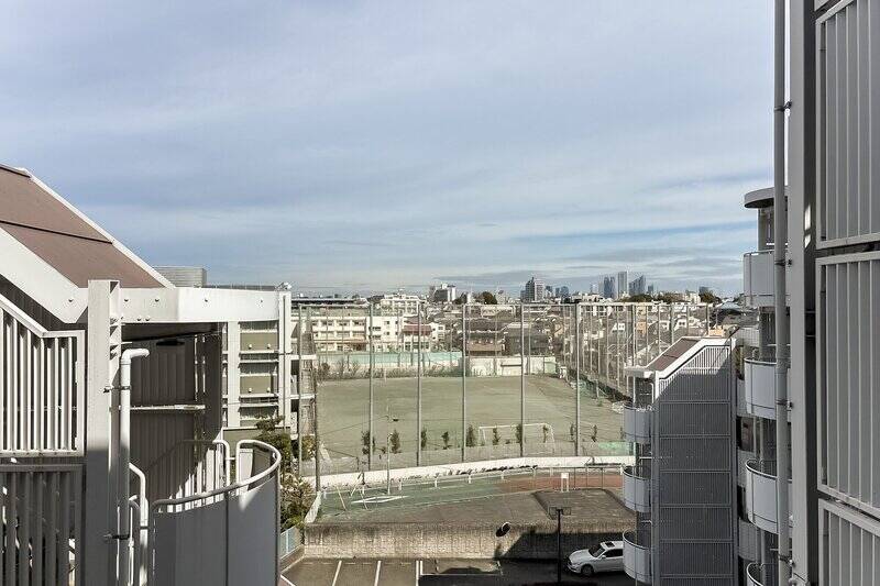 洋室Aからアクセス。正面には「世田谷中学校」のグラウンドが広がっています。手前の道路は地区計画等の指定区域となっており、将来的に道路が拡幅する予定です。