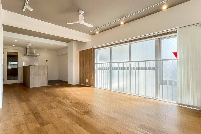 東側の窓はくもりガラス仕様で、光がやわらかく拡散します。天井クロスやキッチンの腰壁はグレーでまとめられ、ウッド調の室内とマッチした落ち着きある配色です。