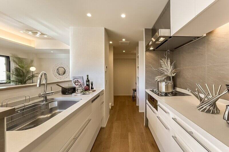 LD側にシンク、壁側にコンロがあるセパレートタイプ。たっぷりと引き出し収納が用意されています。奥に冷蔵庫置き場や洗濯機置き場、可動棚があり……