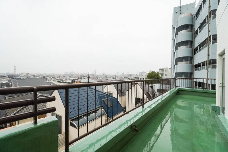 ガラス扉から外に出ると、約20㎡のゆったりとしたルーフバルコニーが広がっています。現在地はマンションの4階。写真はあいにくの雨模様ですが、街を見渡せる気持ちいい眺めでしたよ！