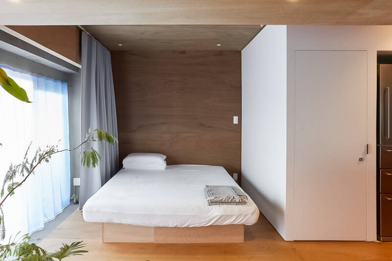 キッチンの奥には、ベッドスペースもひとつなぎで設けられています。ただ、上部にはカーテンレールが備わっているので、カーテンを開けていればひとつなぎならではの開放的な空間に、閉めれば生活感とはおさらば。場面によって使い分けできるのがうれしいですね。写真右手の扉の中は、コンロの裏側まで続くウォークインクローゼット（WIC）。