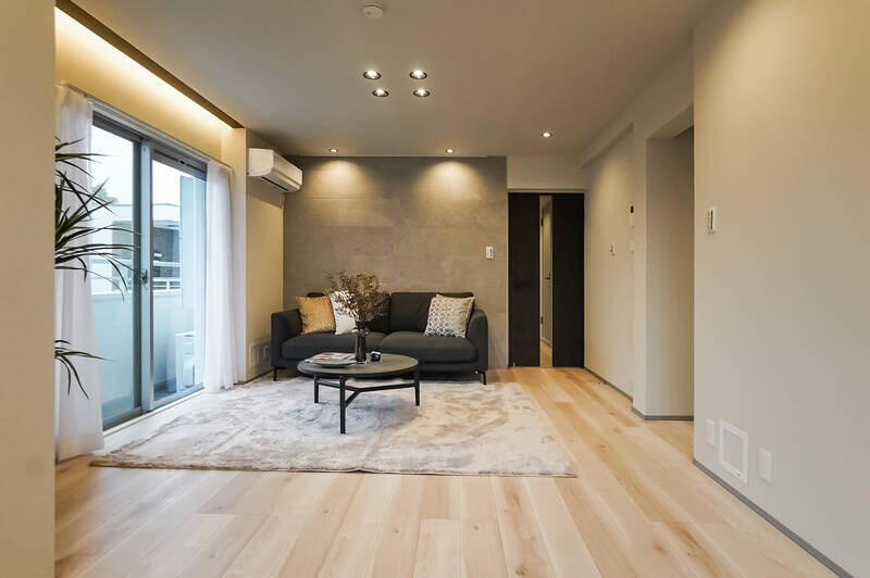 右手の壁の奥がキッチンスペース。正面の壁はアクセントでグレーのタイルが貼られています。ブラックのダウンライトが空間のアクセントに。