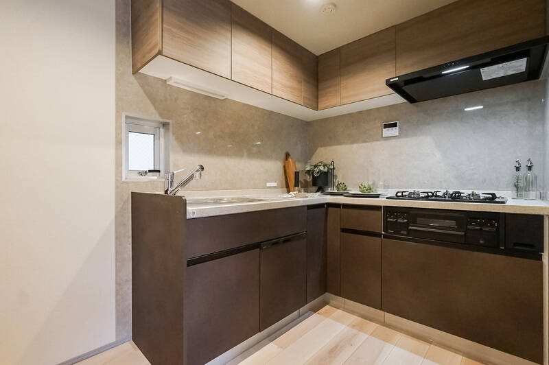 落ち着いた色味が素敵なキッチンは壁で囲まれている独立タイプ。L型で作業効率がよさそう♡ 小さな窓が付いていて換気もできますよ。頼もしい食洗機付き。