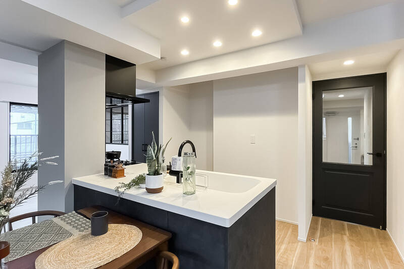 キッチン腰壁や建具はブラックで統一。キッチン背面にはカップボードを置けるスペースが確保されています。