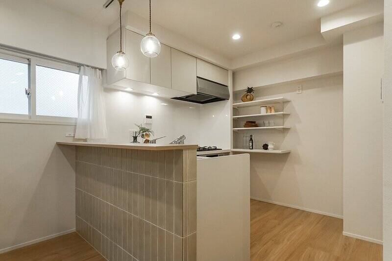 細長いタイルが、やさしい色合いながらも空間をすっきりと見せてくれます。奥には可動棚が付いているので、使いやすい位置に調整できますよ。