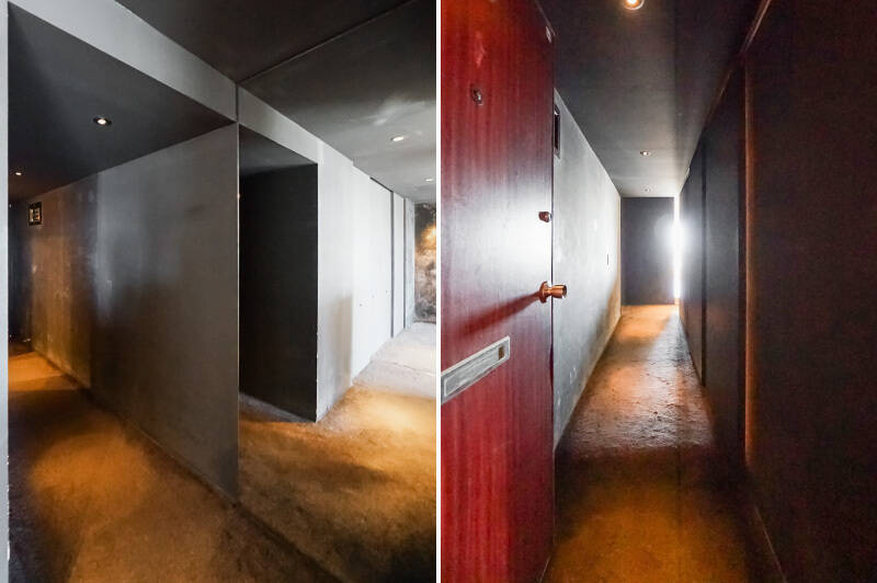 <b>左・</b>玄関に続く廊下の曲がり角には大きなミラーが設置されており、空間がびっくりするほど膨らんで見えます。そして黒で統一された廊下が、まるで舞台袖のように暗い……！／<b>右・</b>玄関側から。未だかつて、これほどに敢えて暗さを演出し、ミステリアスな玄関があったでしょうか。ちなみにカーペット敷きで土間の無い玄関なので、段差につまづく心配はなさそうですよ。