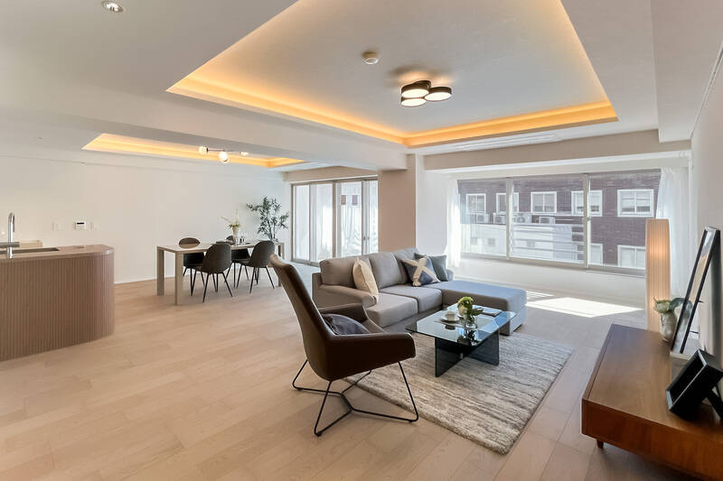 南東向きの大きな窓から光が差し込む、約32.9帖の広々としたLDK。天井には間接照明を設え、梁（はり）の圧迫感を軽減して軽やかな印象に仕上げています。