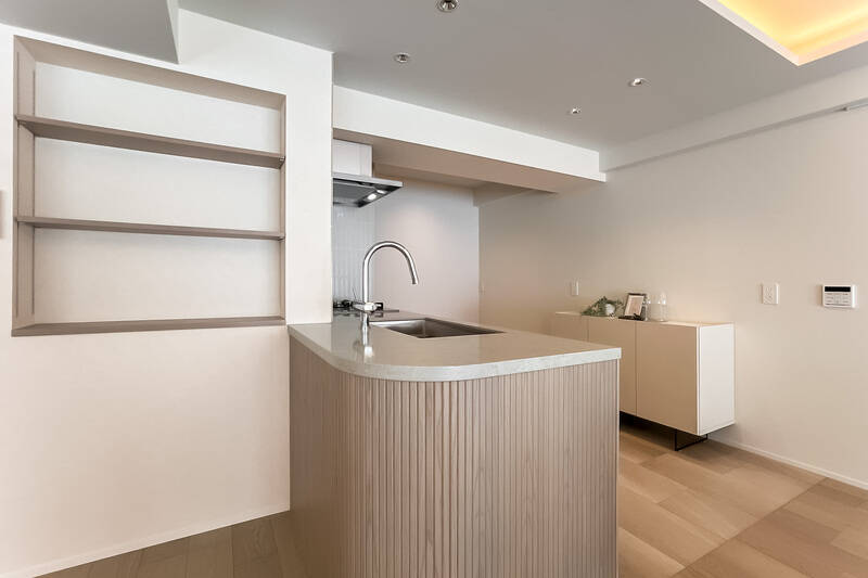 キッチンの腰壁は、角にやわらかなアールを描き、木のリブを施すことで、空間にさりげないアクセントを添えています。