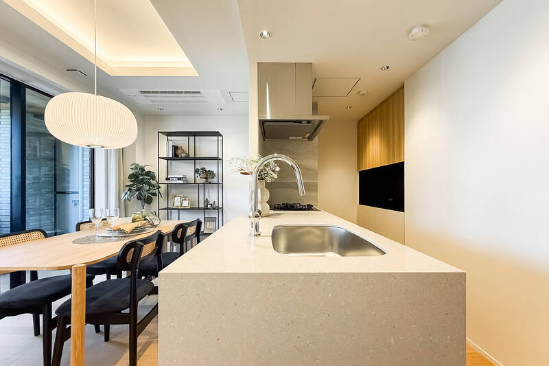 天板はお手入れがしやすく、ダイニングスペースへの料理のサーブもスムーズなフラットタイプです。キッチン背面には備え付けのカップボードがあり、調理家電やキッチンまわりの道具を収納できます。