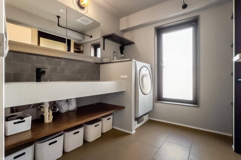 スペースにゆとりを持たせた洗面室。洗面台の壁面にはタイル貼りを施しており、マリンランプもかわいいアクセントに♡  奥の扉からはルーフバルコニーへアクセスできますよ。