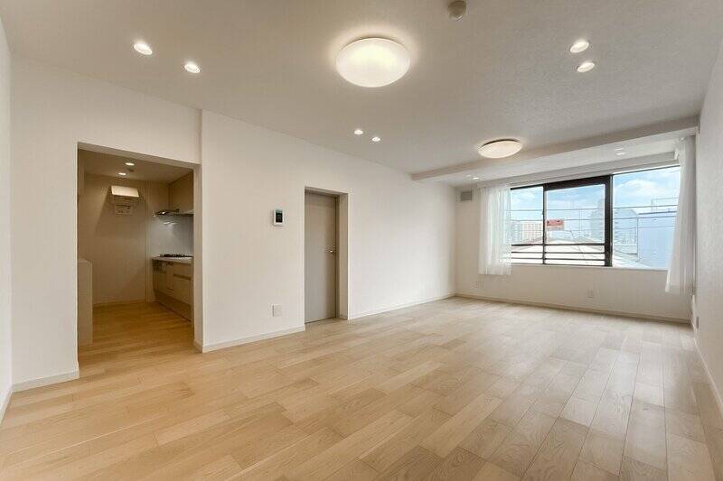 LDKの広さは約20.1帖。南東向きの腰高窓から、やわらかな光が心地よく差し込みます。左手の開口の先はセミクローズドなキッチンに、グレージュの扉の先は洋室Bです。