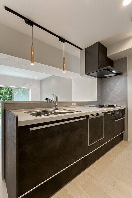 食洗機付きの対面キッチンは、暗めの色味がスタイリッシュ。正面の窓からお庭が見えるので、ご家族やペットが遊んでいるところを見ながら作業ができます。