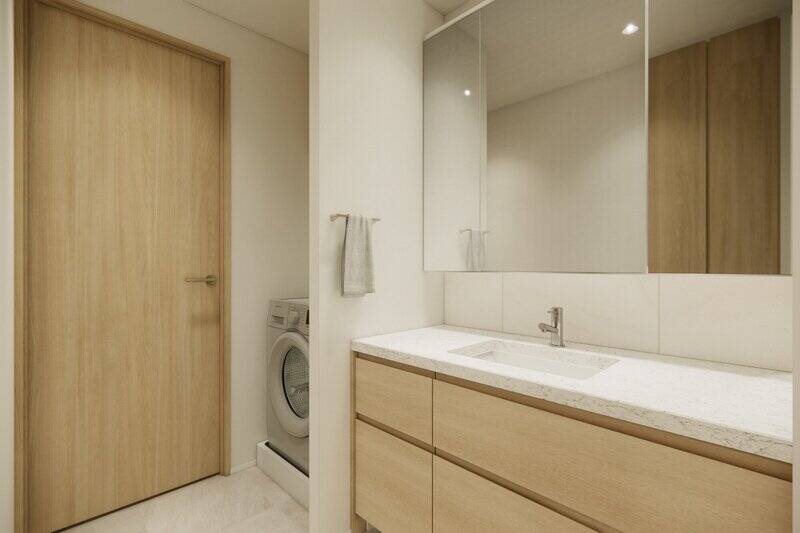 ワイドスパンのオーダー洗面台。壁面にタイルを使用し、上品な印象に仕上げます。洗面台の左手には洗濯機置き場があります。