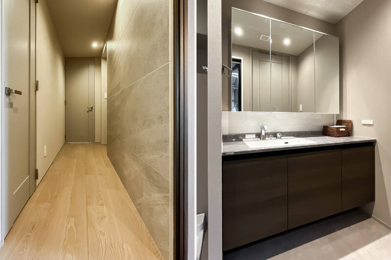 <b>左・</b>廊下の壁面には大判のタイルが貼られ、シックな雰囲気。／<b>右・</b>広いカウンタートップの洗面化粧台。左手には洗濯機置き場が並んでいます。