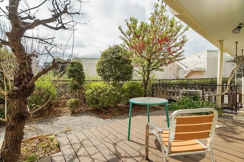 約87㎡もある専用庭に出てみました。LDKに続く窓辺にはウッドデッキが設置されていて、ちょっとリゾートのようないい雰囲気！ 実質2階ほどの高さがあるうえ、正面は商業施設の駐車場跡地なので視線が気になることもなさそうです。