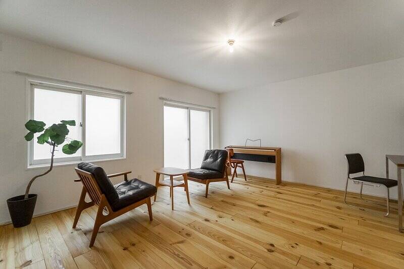 フレキシブルスペースの広さは約12.8帖。足元はほかの空間とちょっと表情を変えて、無垢パイン材です。住戸の北側は、実質半地下階と捉えておくのがよさそう。窓の向こうには、塀で囲まれたドライエリアが広がっていますよ。