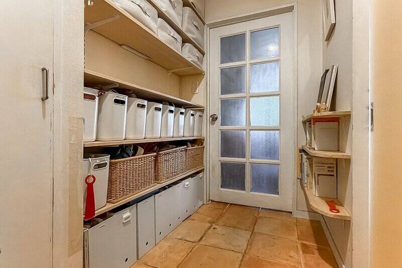 廊下の床材は、テラコッタ風のタイル。壁一面にオープン収納があり、シューズラックとして活用してもよさそう。