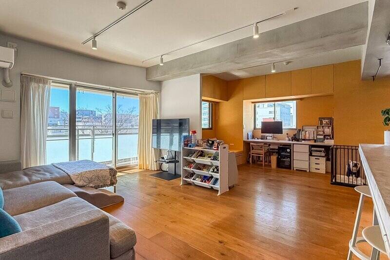 約28帖の広々としたLDK。角住戸のため窓が多く、南側・西側から明るい光が差し込みます。LDKの床材には、表面に天然木が貼られた複合フローリングが採用されています。