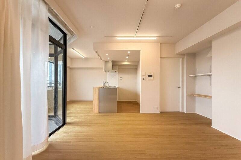 キッチンの床材は防水性のあるコルクタイル貼り。またリビング・ダイニングには、温かみを感じるパイン材の無垢フローリングが採用されています。素足で歩くと気持ち良さそう……！ ペットたちと窓辺でゴロン。なんて暮らしが想像できます。