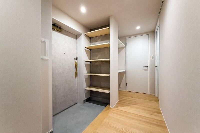 玄関収納も可動棚付き。土間はモルタル塗装仕上げです。写真右奥の扉2枚は、それぞれ洋室BとWTCにつながります。扉の手前にも収納棚が備わっていますね。玄関にワンちゃんのお散歩グッズも置けそうな収納力！