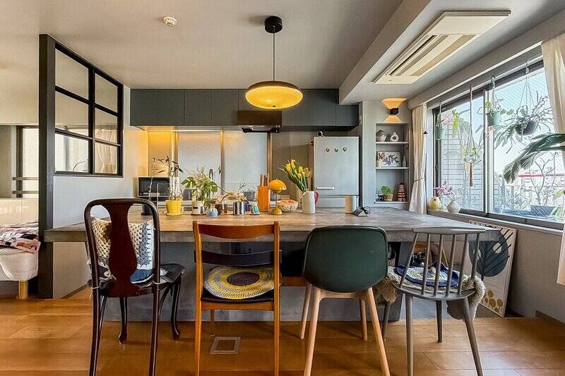 シンクとコンロがセパレートされたⅡ型タイプ。ダイニングテーブルを兼ねたモルタル仕上げの大きなキッチンに、さまざまな機能が詰め込まれています。