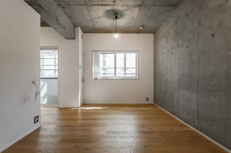 リビングの広さは約9.9帖。天井に加え、壁面もコンクリート躯体を活かした内装です。東向きの腰窓からは、やわらかな日差しが差し込んできます。