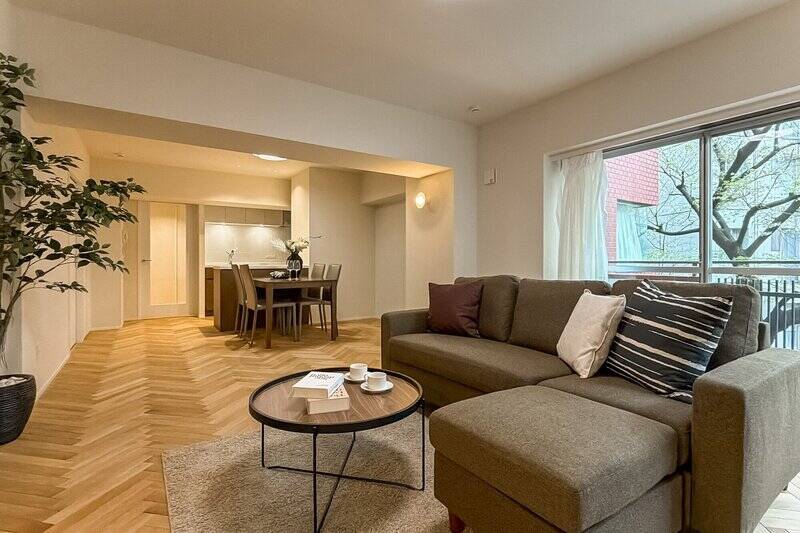 北西と北東向きの窓から、やわらかな光が差し込むLDK。床には、光の角度で表情を変える美しいヘリンボーンのフローリングが張られています。