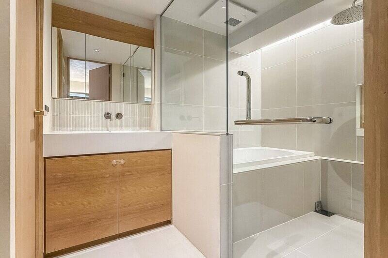 三面鏡が設けられた洗面台も、突板で仕上げられています。そして在来浴室はガラス張りで、なんだかラグジュアリーホテルにいるかのような感覚に！