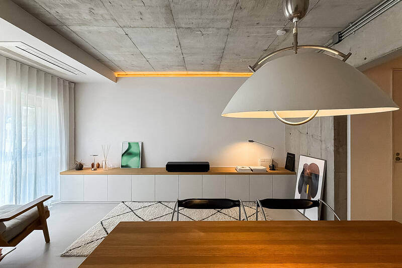 壁一面に造作されたロータイプの収納はベンチとしても機能。アートを飾ったり、テレビボードとして使うこともできそうです。プロジェクターで白壁に映像を投影するのも素敵ですね。