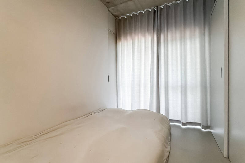 北東側にベッドスペース。こちらもカーテンレールは天井に取り付けられています。右手には壁一面に造作された大容量のクローゼット、さらに左手奥にもコンパクトな収納を確保しています。