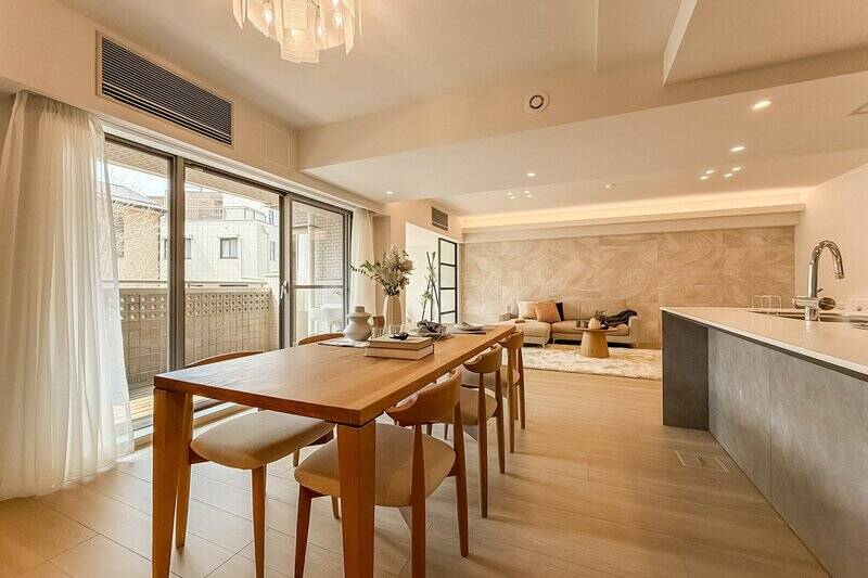 リビングの壁一面には石調の大判タイル。エアコンはサッシ上部に埋め込まれています。