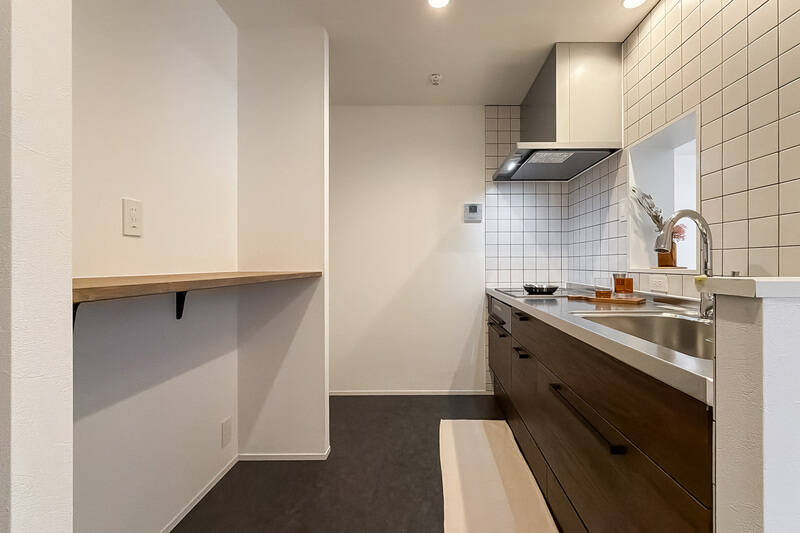 背面には長いカウンターが。下の空洞にワゴンを置いてストック品を整理したり、ゴミ箱を置いたりできそうですね。上下にコンセントが付いていますよ。袖壁の向こうが冷蔵庫置き場。