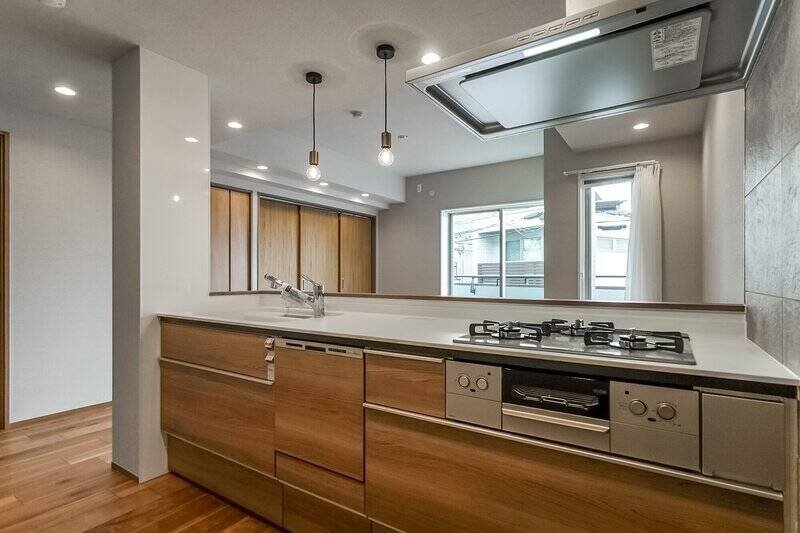 キッチンは、3口ガスコンロと食洗機を完備。背面には冷蔵庫置き場とカップボードを置けるスペースを確保します。