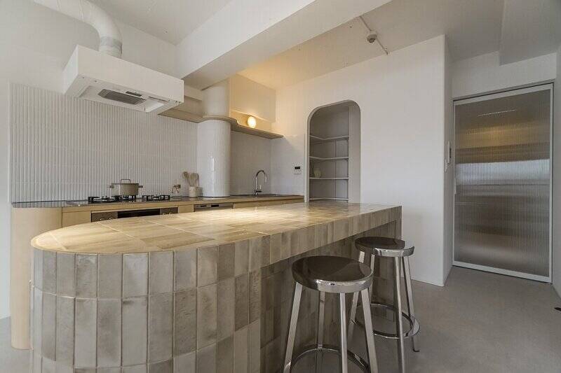 ひとつひとつ濃淡の違うタイルを貼りあげた、こだわりのキッチンカウンター。光を受けてツヤツヤっと輝きます。カーブを描いたデザインが、キッチン奥の柱やパントリーの開口部と響きあって、とってもおしゃれ!