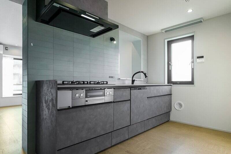 キッチンはブラック系でまとめられたワイドサイズ。3口コンロに食洗機、タッチレス水栓が備わっています。