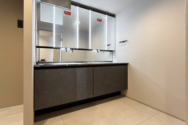 ダブルシンクの洗面化粧台。おふたり並んで身支度していただけます。横に洗濯機置き場がありますよ。