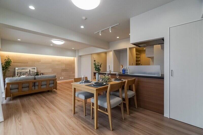 左手の壁面は、間接照明とエコカラットで品のいい雰囲気に仕上げられています。右手前に写っているのは奥行きの深い物入れです。扉付きなので、生活感をスマートにシャットアウトすることができますよ。