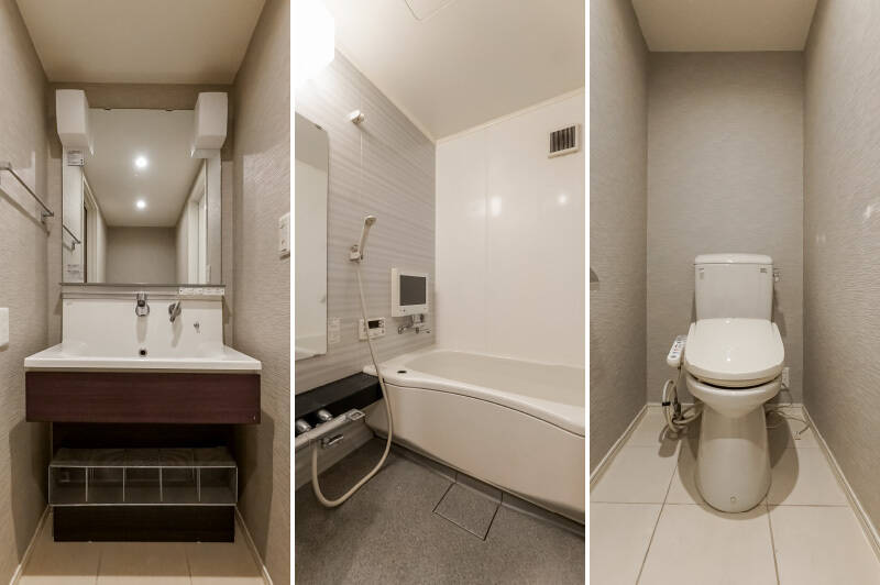 住戸内の内装とトーンを合わせた、モダンテイストな水まわり。洗面室内にトイレがあります。浴室にはテレビが備わっています。