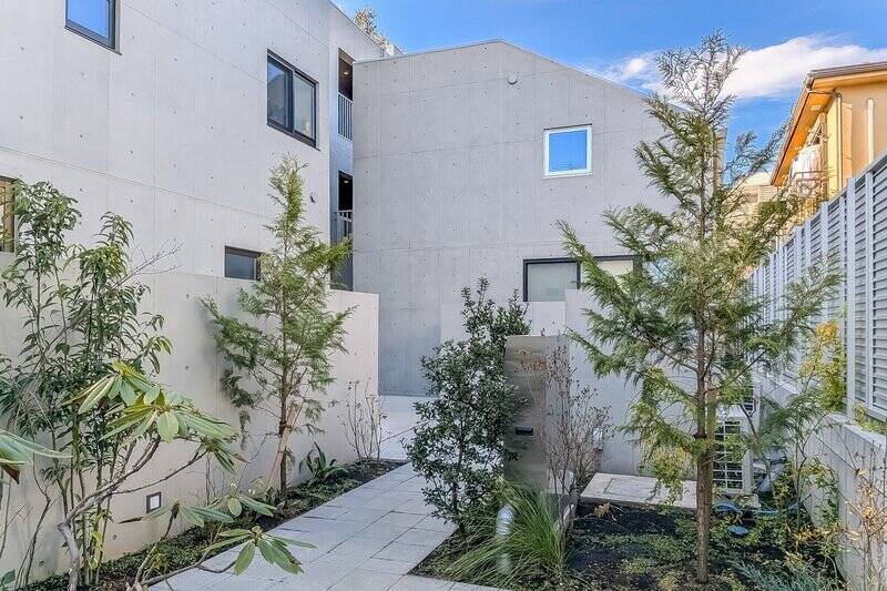 東急田園都市線「駒沢大学」駅から徒歩6分の旗竿地に建つコーポラティブハウス。コンクリートの無機質な表情と直線的なラインが、スタイリッシュな印象です。