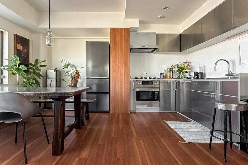 壁付けのL型キッチンの背面には、ダイニングスペースがゾーニングされています。