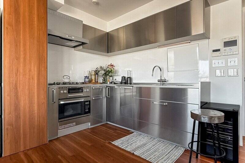 スタイリッシュなステンレスキッチン。食洗機に加え、ビルトインオーブンレンジまで完備されており、デザイン性だけでなく機能性も兼ね備えています。