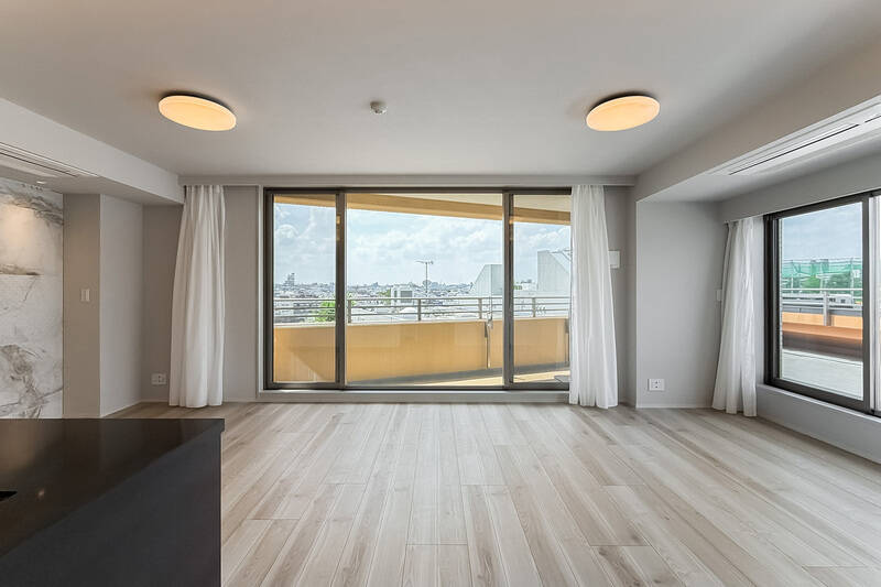 南西と北西の2方に大きな開口があり、外には大きな空と街並みが広がっています。