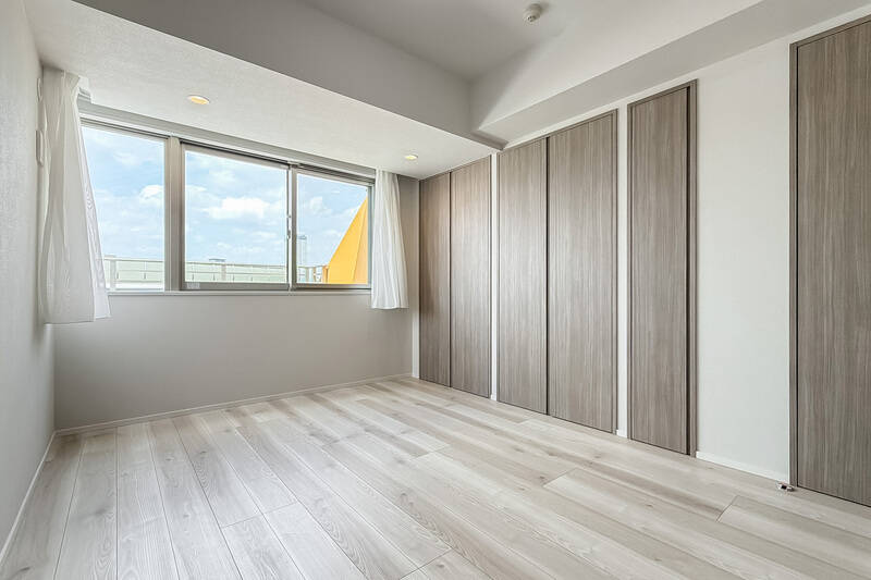 先ほどのルーフバルコニーに面した北西向きの居室。カーテンで隠れていますがコーナーサッシのため、ベッドに寝転べば空が広く見えそうです。全4箇所クローゼットを備えていますよ。