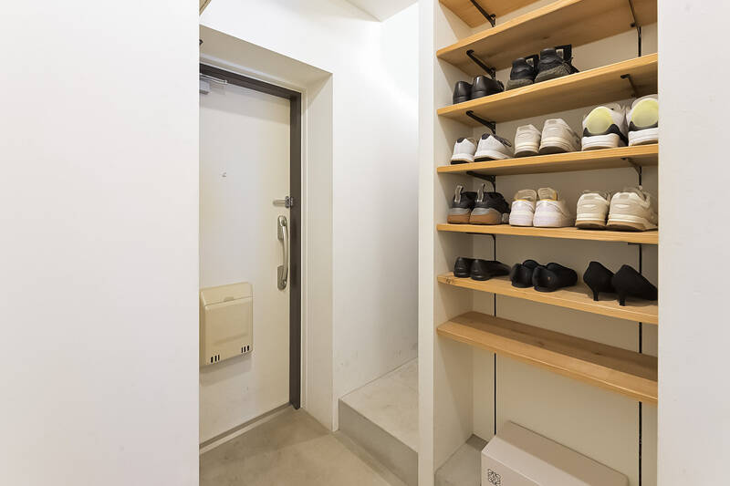 玄関はモルタル仕上げで、無機質なデザインに。可動棚のほか、正面に見える段差の奥にシューズインクローゼット（SIC）も用意されています。