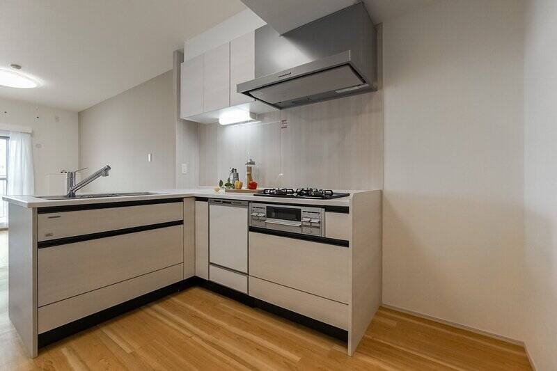 作業しやすそうなL字型のキッチンは食洗機を完備。冷蔵庫置き場もゆったりとしています。